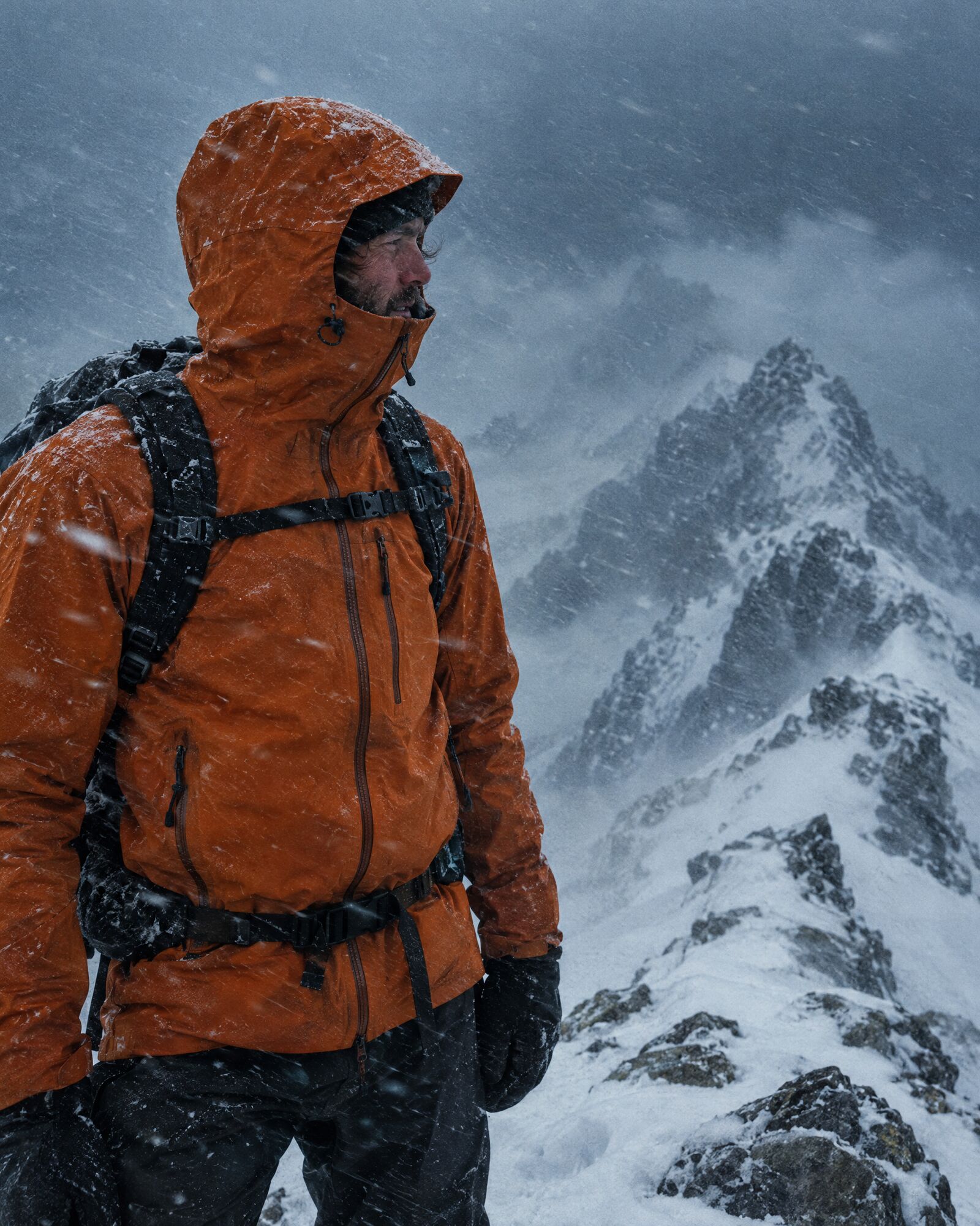 Hiker in a waterproof shell on a stormy mountain ridge